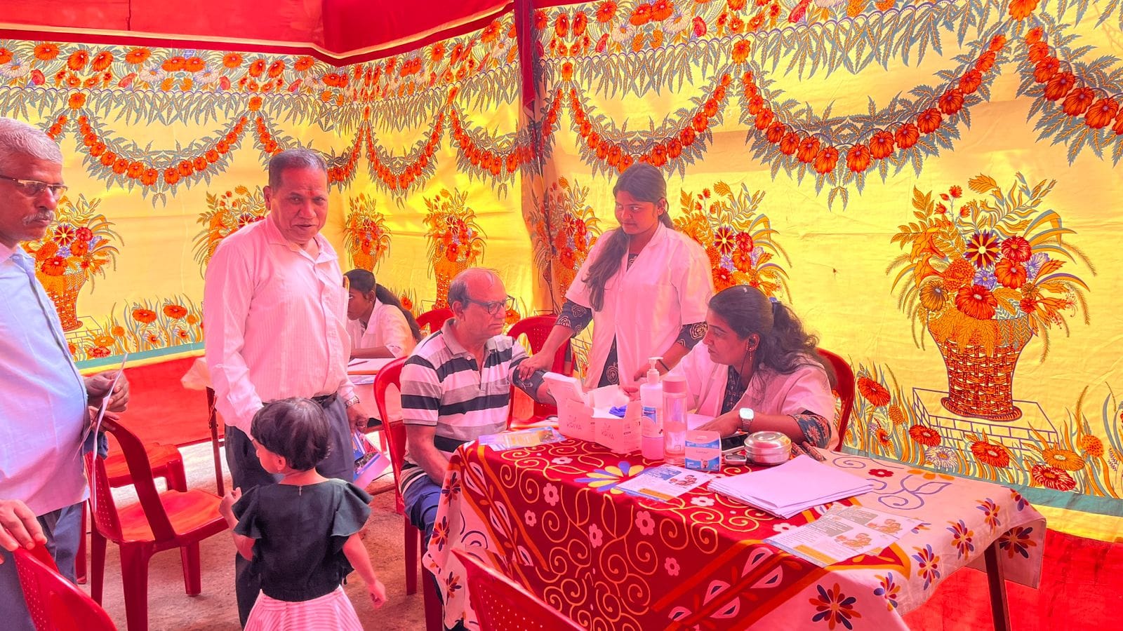 Volunteers recording patient details at the camp table